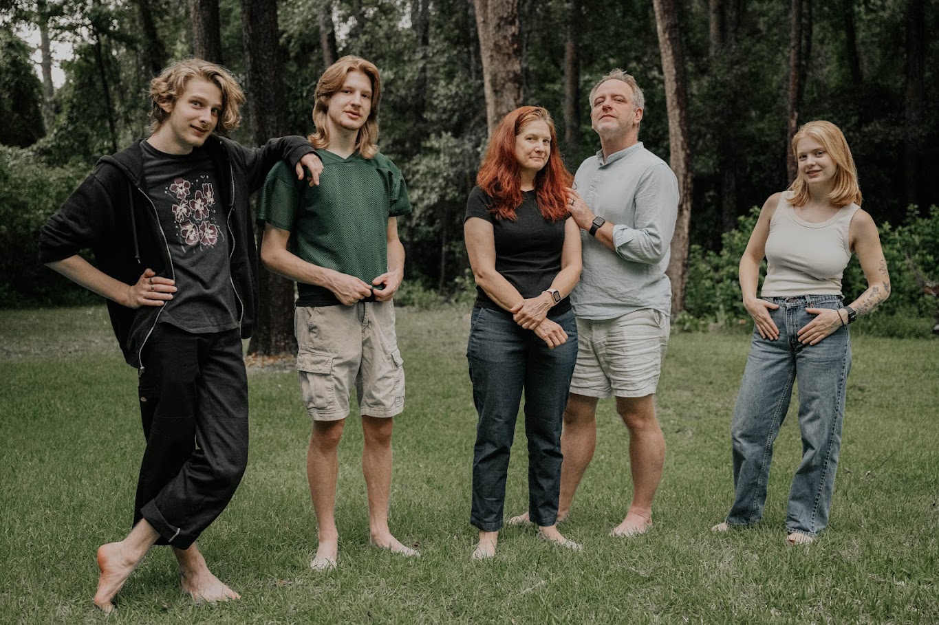 The Bennage family posing barefoot in the woods